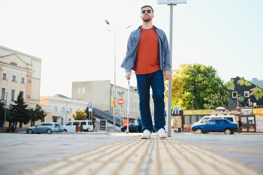 Deficiente visual andando na rua com bengala