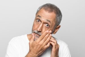 Idoso mostrando o olho.